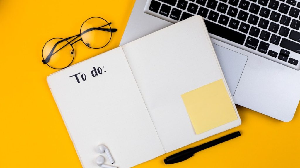 Home office desk workspace with laptop on yellow background. Flat lay, top view girl boss work business concept. Work at home concept on coronavirus quarantine